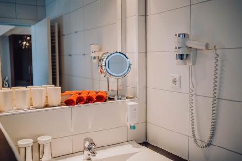 a bathroom with a mirror and a sink at Pension Sterntaler in Rheinhausen