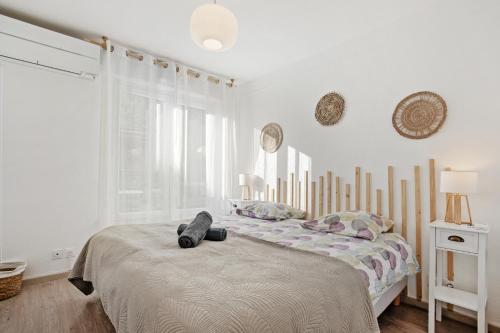 a white bedroom with two beds and a window at Un Havre De Paix in Fréjus