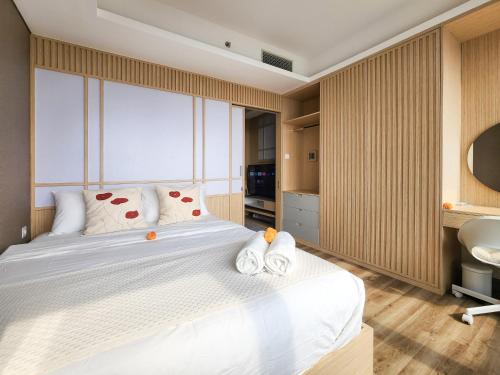 a bedroom with a bed and a sink and a tub at The Smith Apartment - Alam Sutera by Nagisa Bali in Kampungklapa 2