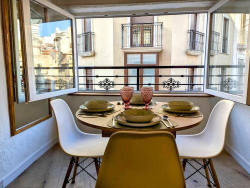 a dining room with a table and chairs and windows at Casa San Pedro 3 in Murcia