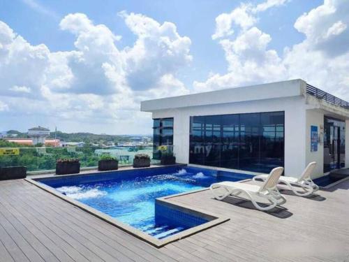 ジョホールバルにあるHaider's Homestay D'Summit Residence Kempas JBのスイミングプールと椅子2脚付きの家