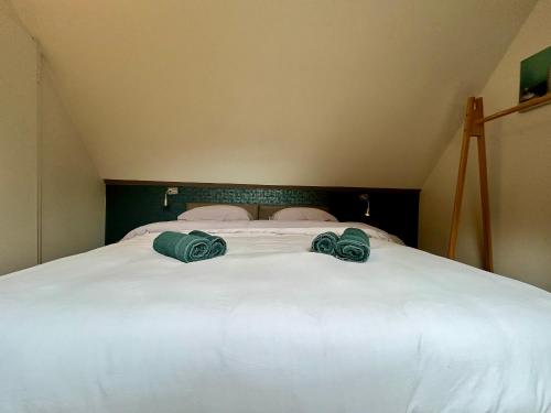 a large white bed with two green towels on it at Chez Dom in Malmedy