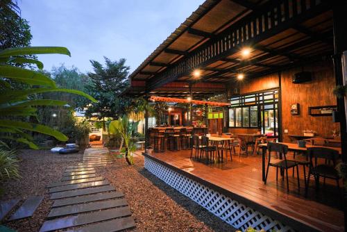 un restaurant avec des tables et des chaises sur une terrasse en bois dans l'établissement Standard, à Ban Phrom Min