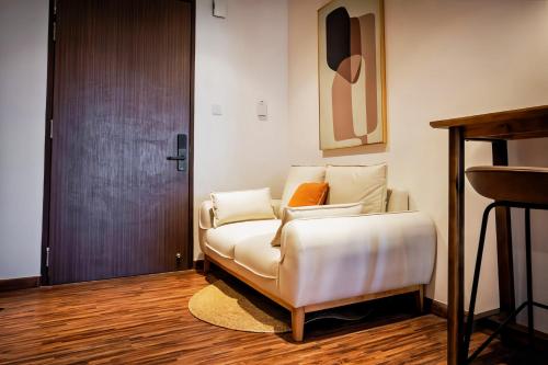 a white bed in a room with a wooden floor at K Avenue Kota Kinabalu in Donggongon
