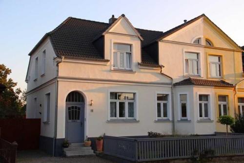 a large white house with a blue door at Ferienwohnung "Mittendrin" in Neubrandenburg