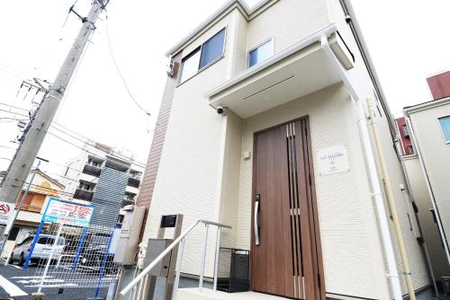 a building with a brown door on a street at NYHotel 2 新宿2階建て3室1バスルーム1シャワー2トイレ in Tokyo