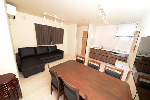 a living room with a table and a couch at NYHotel 2 新宿2階建て3室1バスルーム1シャワー2トイレ in Tokyo