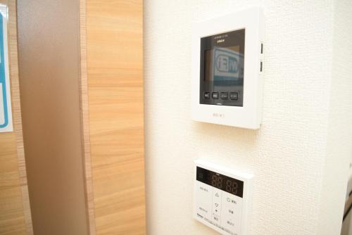 a room with a clock on the wall at NYHotel 2 新宿2階建て3室1バスルーム1シャワー2トイレ in Tokyo