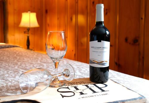 a bottle of wine and a glass on a table at Whitneys Inn at Black Mountain in Jackson