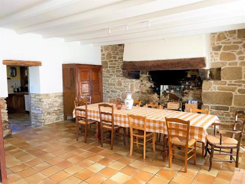 une cuisine et une salle à manger avec une table et des chaises dans l'établissement Grande maison familiale au cœur du Finistère, à Landudal