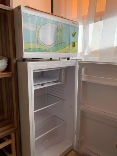 a refrigerator with a microwave on top of it at Chasa Bazzi in Scuol