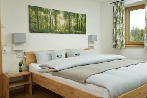a bedroom with a large bed with a wooden frame at Auszeit Ferienhof in Görisried