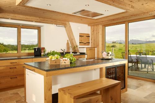 a kitchen with a counter and some windows at Auszeit Ferienhof in Görisried
