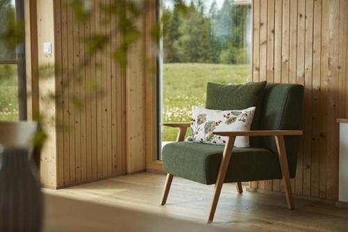 a green chair in a room with a window at Auszeit Ferienhof in Görisried