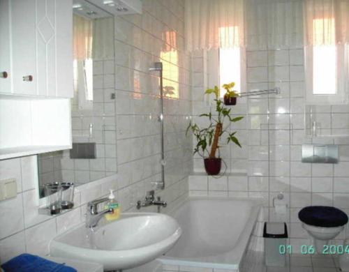 a white bathroom with a tub and a sink at Ferienwohnung in der Innenstadt in Neubrandenburg