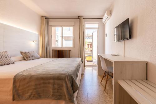 a hotel room with a bed and a desk at Eco Avenida Hotel & Parking in Benicàssim