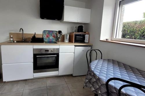 une cuisine avec un évier et une cuisinière four supérieur dans l'établissement 2 pièces avec terrasse, à Malestroit