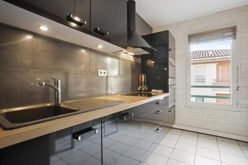 a large kitchen with a sink and a window at Un Havre De Paix in Fréjus