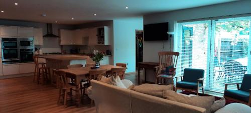 a living room and kitchen with a couch and a table at Woodlands Peaceful Bedrooms in Hemingford Grey