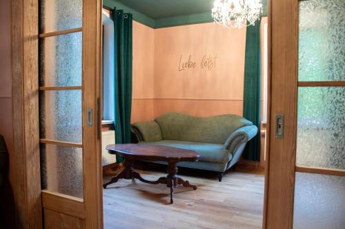 a room with a chair and a table and a chandelier at Villa Elbling in Radebeul