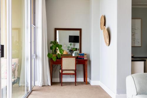 a room with a desk with a chair and a mirror at Royal Boutique Hotel in Cape Town