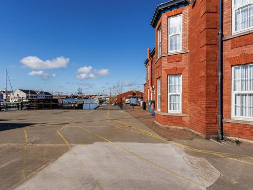 an empty parking lot next to a brick building at 1 Abdiel House · Modern Apartment by Hartlepool Marina Relaxing Pass the Keys in Hartlepool