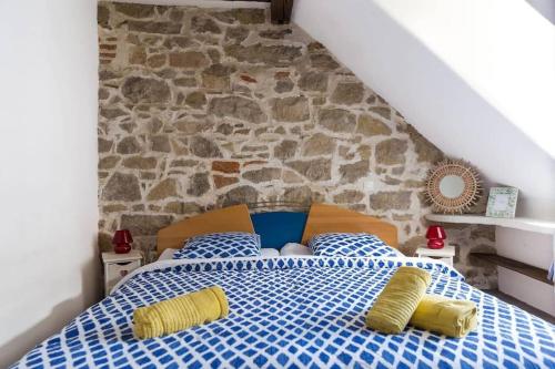 - une chambre dotée d'un lit bleu et blanc avec des oreillers jaunes dans l'établissement Nid douillet en ville - l'Atipik, à Mulhouse