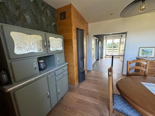 une cuisine avec une table et une salle à manger dans l'établissement L'Oustal du Bourg, à Laguiole