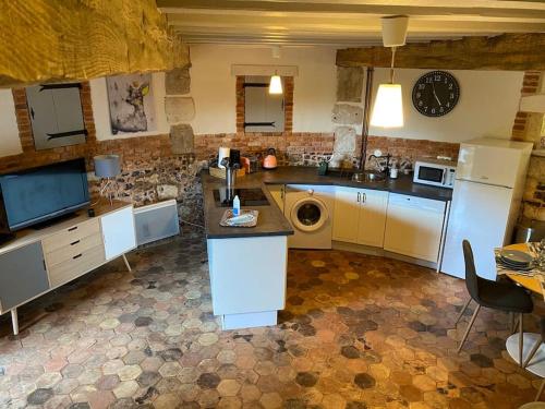 een keuken met een wastafel en een vaatwasser bij Le Colombier d Yville in Héronchelles