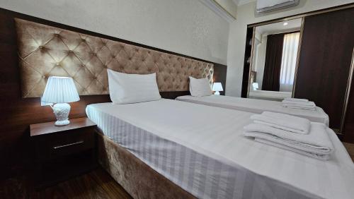 a bedroom with a large bed with towels on it at Grand Turon Plaza Hotel in Tashkent