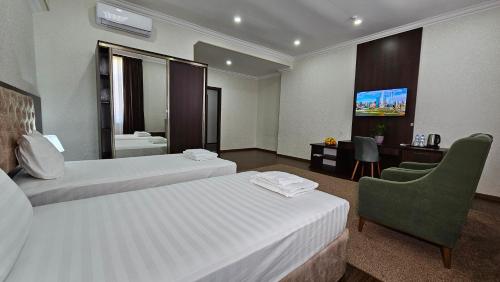a hotel room with two beds and a television at Grand Turon Plaza Hotel in Tashkent