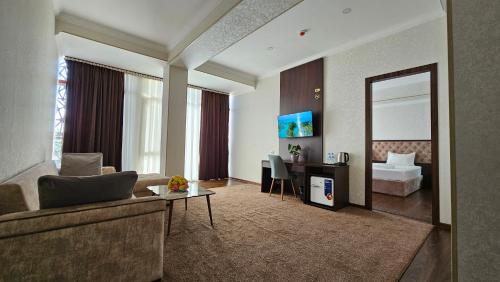 a living room with a couch and a table and a mirror at Grand Turon Plaza Hotel in Tashkent