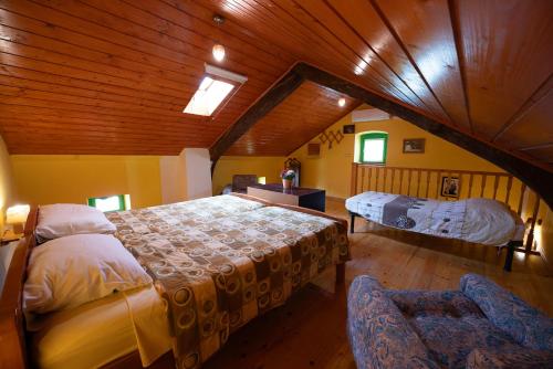 une chambre avec deux lits dans un grenier dans l'établissement Holiday house Mario, à Peresiji