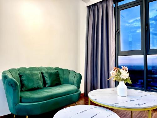 a living room with a green couch and a table at K Avenue Kota Kinabalu in Donggongon