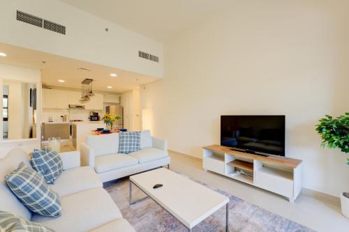 a living room with white furniture and a flat screen tv at Serene 2-Bed Haven in Jumeirah Golf Estates in Dubai