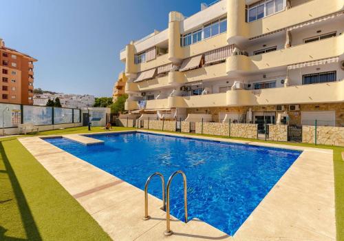 a swimming pool in front of a building at Gå nemt til Fuengirola strand, restauranter, butikker, padel og meget mere! in Las Lagunas Mijas