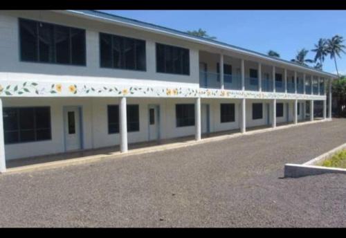 a large white building with a lot of windows at Maninoa Surf Accommodation in Apia