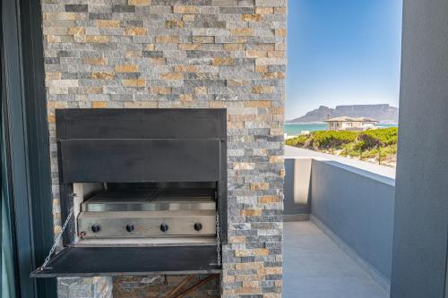 a brick oven with a view of the beach at Beachfront Apartment with wrap around terrace in Blouberg, 04 Azul in Bloubergstrand