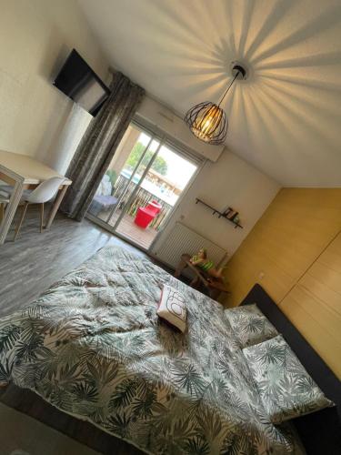 a large bed in a room with a large window at Studio zen piscine in Balaruc-les-Bains