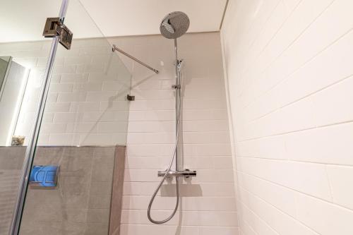 a shower with a shower head in a bathroom at Beachfront Apartment with wrap around terrace in Blouberg, 04 Azul in Bloubergstrand