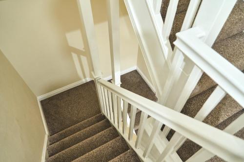 a staircase with white railings and a stair case at F&Fs in Nuneaton