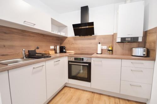a kitchen with white cabinets and a sink at AT WEINMEISTER - freundlich & ruhig in Gütersloh