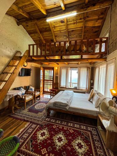 a bedroom with a large bed and a loft at Odyssey Stays Sathkol in Mukteshwar