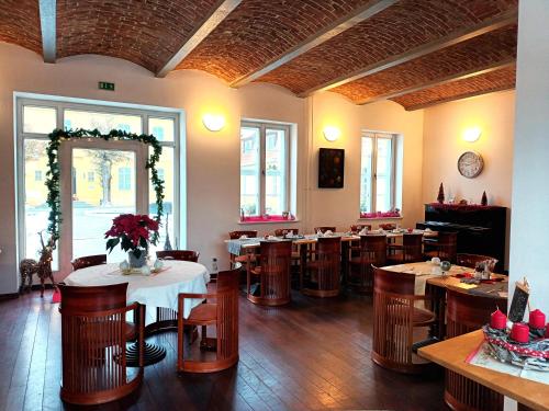 a restaurant with tables and chairs in a room at Hotel Vierseithof Luckenwalde in Luckenwalde