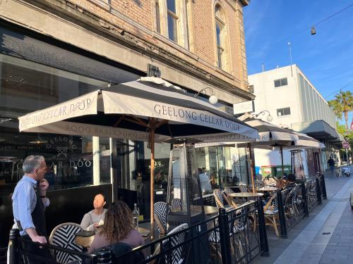 a group of people sitting at an outdoor restaurant at Modern apartment in Central Geelong! in Geelong