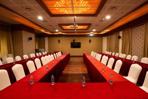 a conference room with a red table and chairs at Southern Star,Davangere in Dāvangere