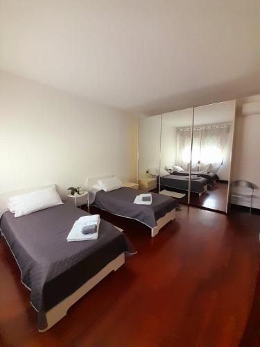 a bedroom with two beds and a mirror at Sweet House in Solesino