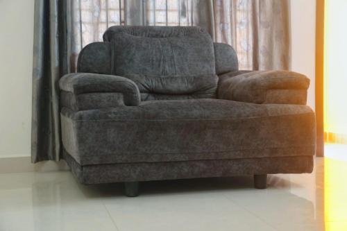 a chair and a recliner in a living room at CM Stays Service Apartment - Near Chennai Airport - Pallavaram in Chennai