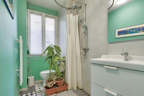 une salle de bain avec un lavabo et des toilettes et une fenêtre dans l'établissement Appart calme à Buttes-Chaumont, à Paris