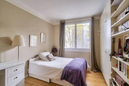 une petite chambre avec un lit et une fenêtre dans l'établissement Appart calme à Buttes-Chaumont, à Paris